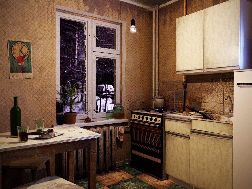 Retro kitchen with beige cabinets, gas stove, exposed bulb, and potted plants on the windowsill by a double window.